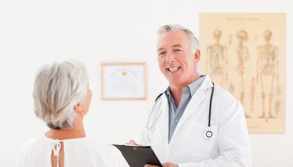 Överläkare talar med sin sjuka patient — Stockfoto