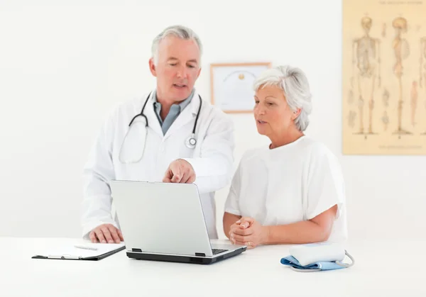 Dokter dan pasiennya melihat laptop — Stok Foto