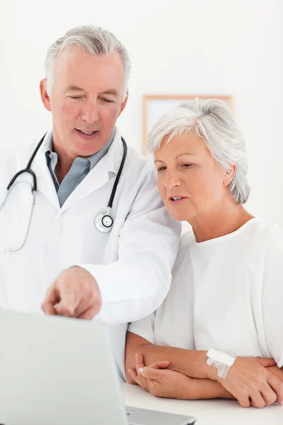Doctor y su paciente mirando el portátil —  Fotos de Stock