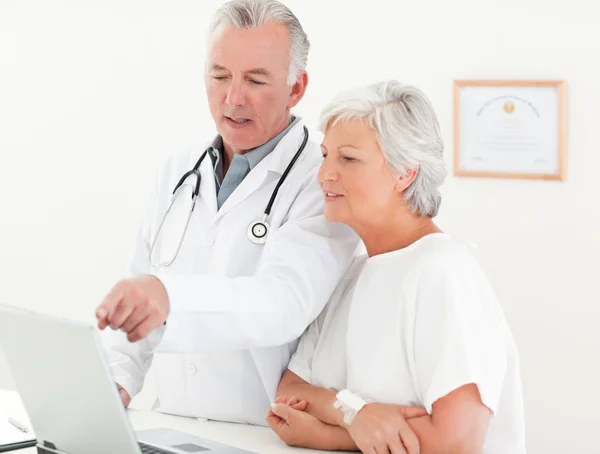Doktor i jego pacjent patrząc na laptopie — Zdjęcie stockowe