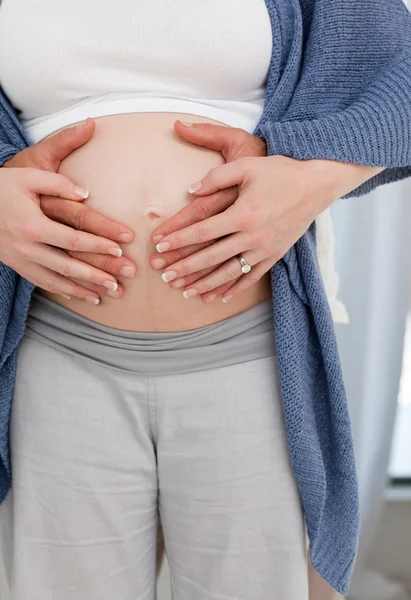 Mão de casal na barriga da mulher grávida — Fotografia de Stock