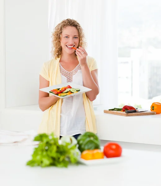 Красива жінка їсть овочі — стокове фото