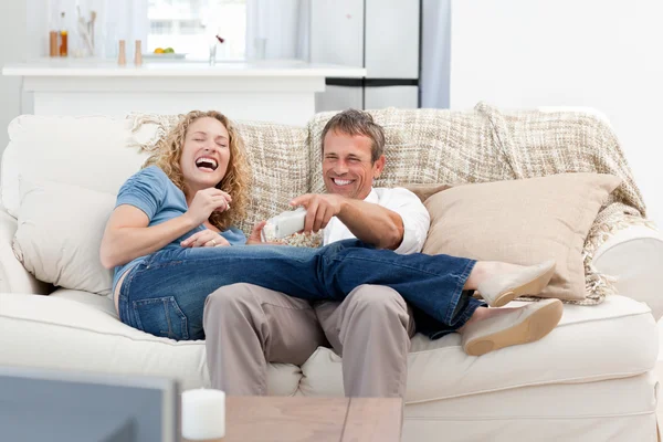 Älskare tittar på tv i vardagsrummet hemma — Stockfoto