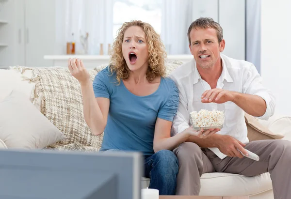 Любители смотрят телевизор в гостиной на дому — стоковое фото