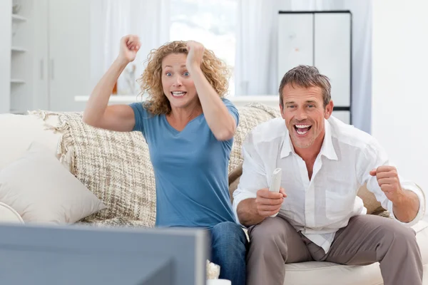 Milenci sledování televize v obýváku doma — Stock fotografie