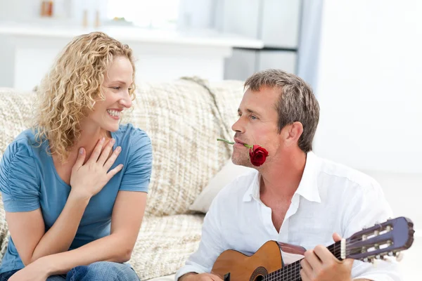 Романтик, играющий на гитаре для ее жены дома — стоковое фото