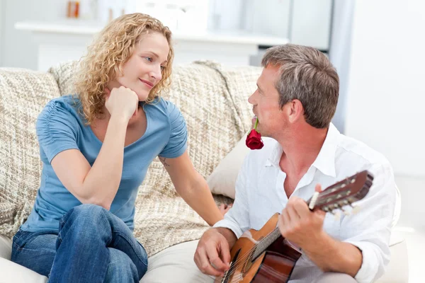 로맨틱 남자 집에서 그녀의 아내를 위해 기타를 연주 — 스톡 사진