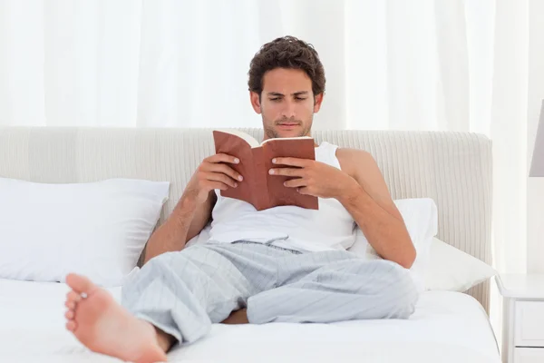Ember Olvasson egy könyvet az ágyra — Stock Fotó
