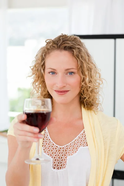 Vrouw op zoek naar de camera met haar drinken van wijn — Stockfoto