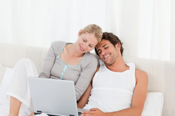 Entzückendes Paar schaut auf seinen Laptop auf dem Bett — Stockfoto
