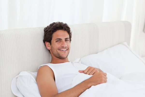 Handsome man lying down in his bed — Stock Photo, Image