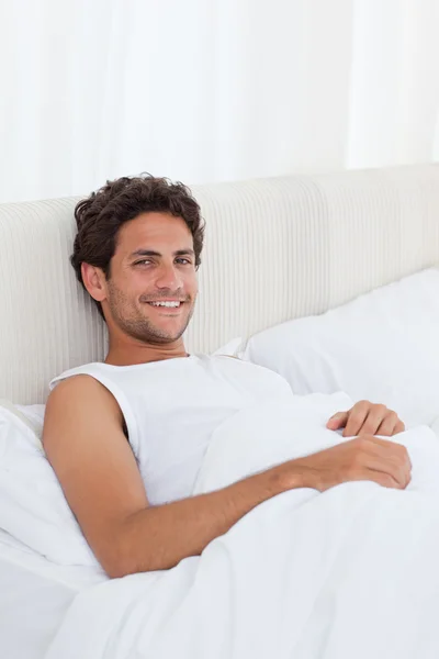 Przystojny mężczyzna leżenia w łóżku — Zdjęcie stockowe