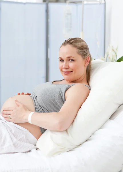 Schwangere junge Frau auf einem Krankenhausbett — Stockfoto