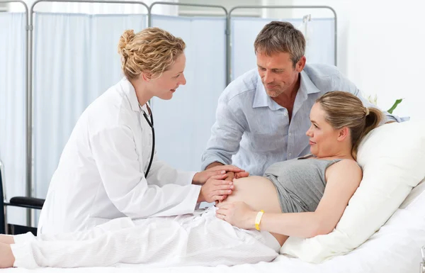 Pregnant woman with her husband listening to the nurse — Stock Photo, Image