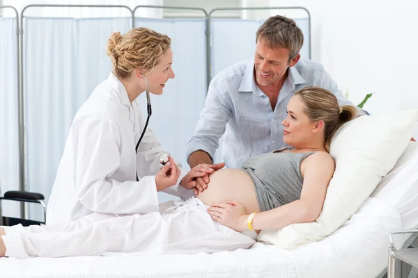 Gravid kvinna med sin man lyssnar på sjuksköterskan — Stockfoto