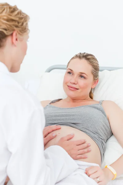 看護師の彼女の妊娠中の患者を安心させる — ストック写真