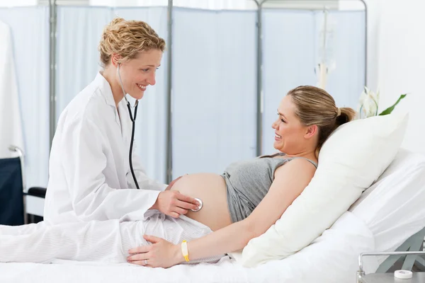 Sjuksköterska lugnande hennes gravid patient — Stockfoto