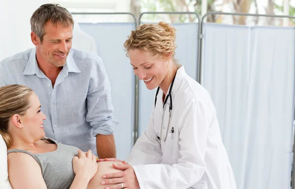 Pregnant woman with her husband listening to the nurse — Stock Photo, Image