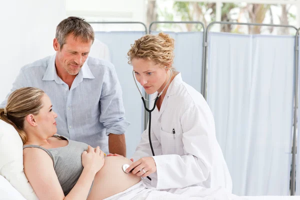 Kobieta w ciąży z mężem, słuchając pielęgniarka — Zdjęcie stockowe