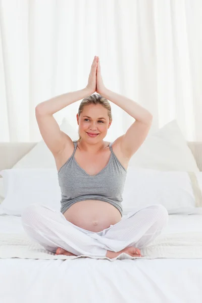Praktykowanie jogi na jej łóżku kobieta w ciąży — Zdjęcie stockowe