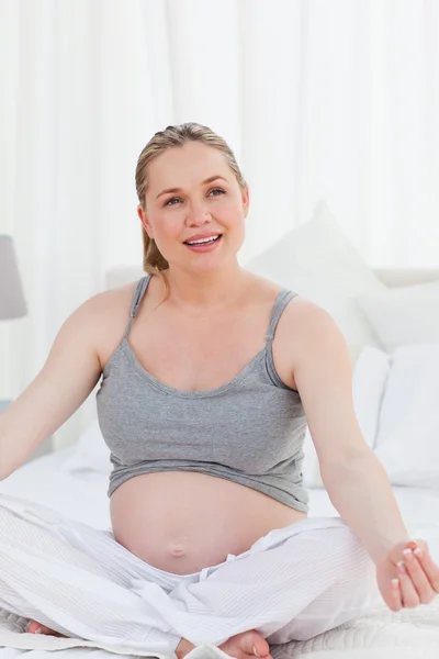 Έγκυος γυναίκα την πρακτική της γιόγκα στο κρεβάτι της — Φωτογραφία Αρχείου