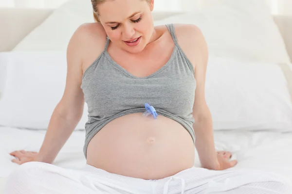 Kobieta w ciąży z manekina dziecka na brzuchu w domu — Zdjęcie stockowe