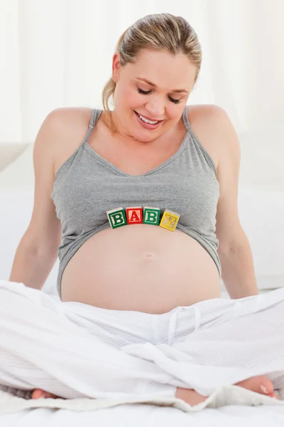 Mulher grávida com cubos de bebê na barriga — Fotografia de Stock