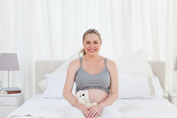 Беременная женщина с мягкой игрушкой — стоковое фото