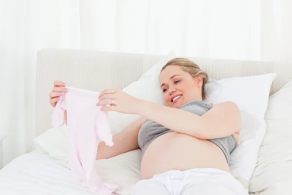 Ganska gravid kvinna med barnkläder — Stockfoto