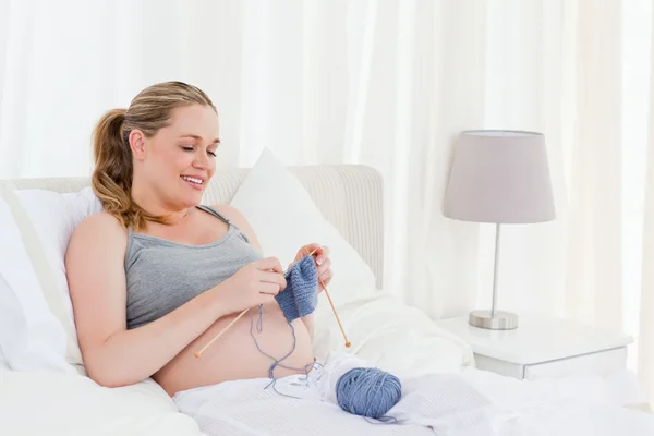 Αξιολάτρευτο έγκυος γυναίκα που κεντά στο κρεβάτι της — Φωτογραφία Αρχείου
