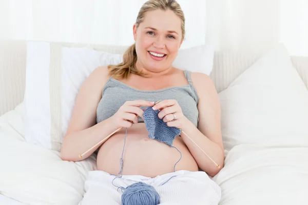 Αξιολάτρευτο έγκυος γυναίκα που κεντά στο κρεβάτι της — Φωτογραφία Αρχείου