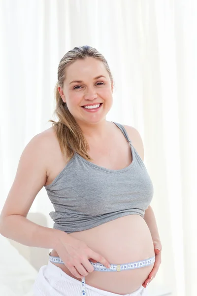 Primer plano de una mujer midiendo su vientre —  Fotos de Stock