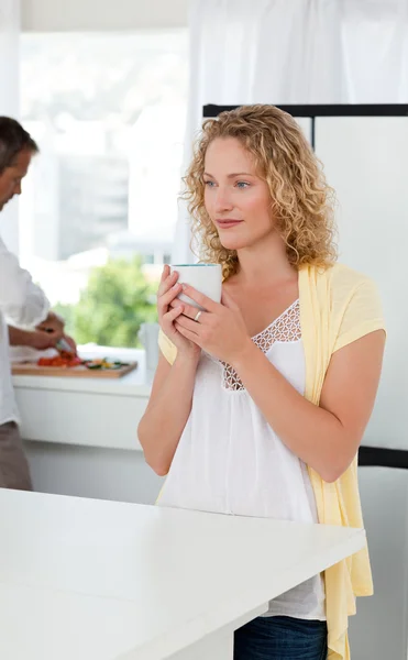 Hezká žena pití čaje ve své kuchyni — Stock fotografie