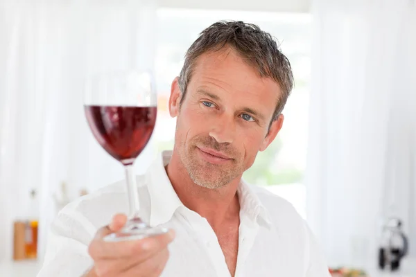 Uomo con il suo bicchiere da vino nella sua cucina — Foto Stock