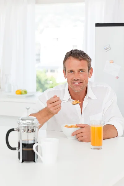 Handsome man having his breakfast in the kitchen — Stock Photo, Image