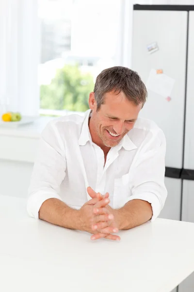 Yakışıklı adam mutfağında oturan — Stok fotoğraf