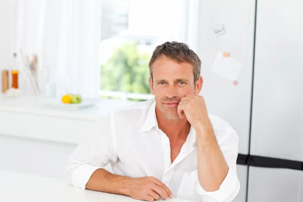 Hombre guapo sentado en su cocina —  Fotos de Stock