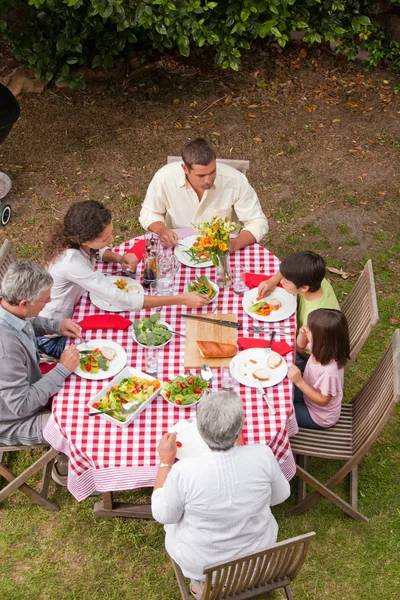 Rodina jíst venku v zahradě — Stock fotografie