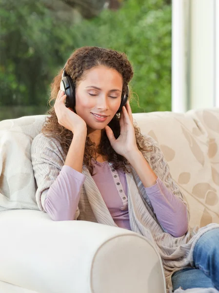 Stralende vrouw luisteren naar muziek — Stockfoto