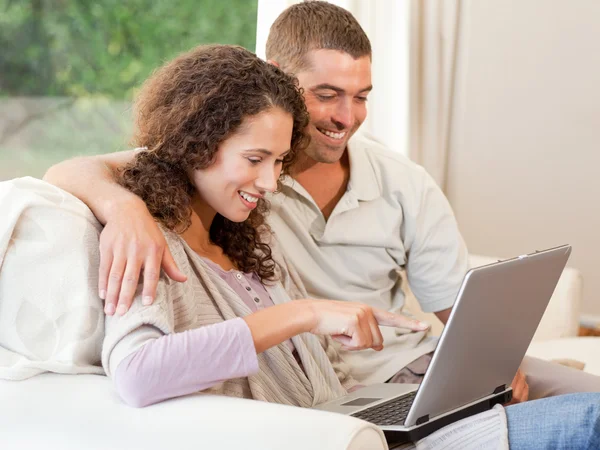 Casal trabalhando em seu laptop em casa — Fotografia de Stock