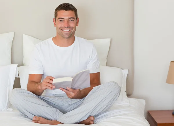 Adam yatakta kitap okuma — Stok fotoğraf