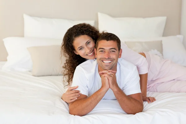 Hezká žena objímala svého manžela na své posteli doma — Stock fotografie