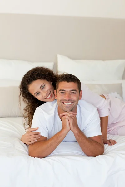 Красивая женщина обнимает мужа на кровати дома — стоковое фото