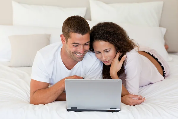 Schönes Paar schaut auf seinen Laptop — Stockfoto