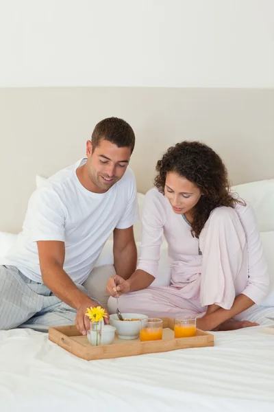 自宅で自分のベッドで朝食を持っているカップル — ストック写真