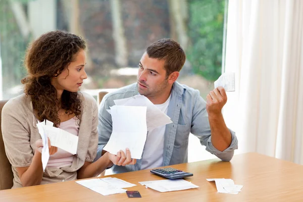 Casal jovem calculando suas contas domésticas — Fotografia de Stock