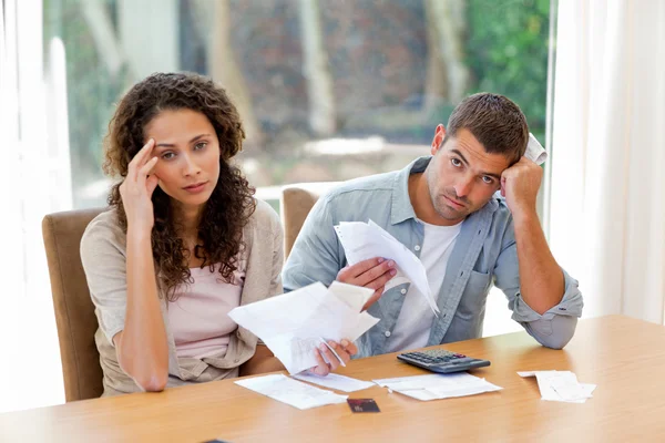 Casal jovem calculando suas contas domésticas — Fotografia de Stock