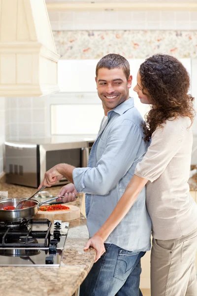 Woman hugging her husband while he is cooking — Stock Photo, Image