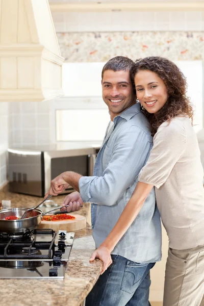Mujer abrazando a su marido mientras él está cocinando — Foto de Stock