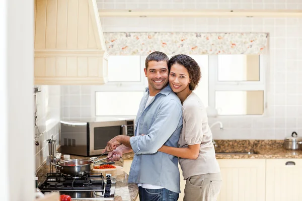 Γυναίκα που αγκαλιάζει τον σύζυγό της, ενώ αυτός είναι το μαγείρεμα — Φωτογραφία Αρχείου